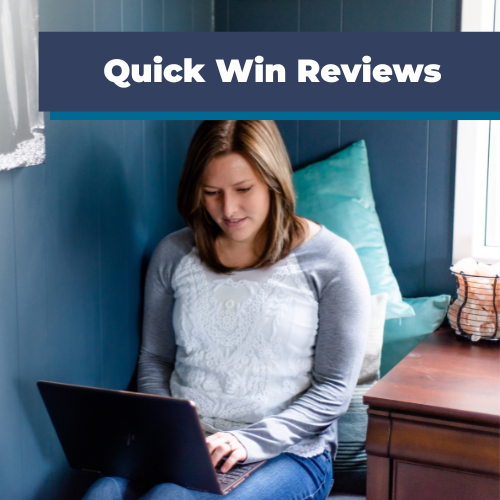 Woman using a laptop on a couch against a blue wall and wooden side table with "Quick Win Reviews" text overlay.