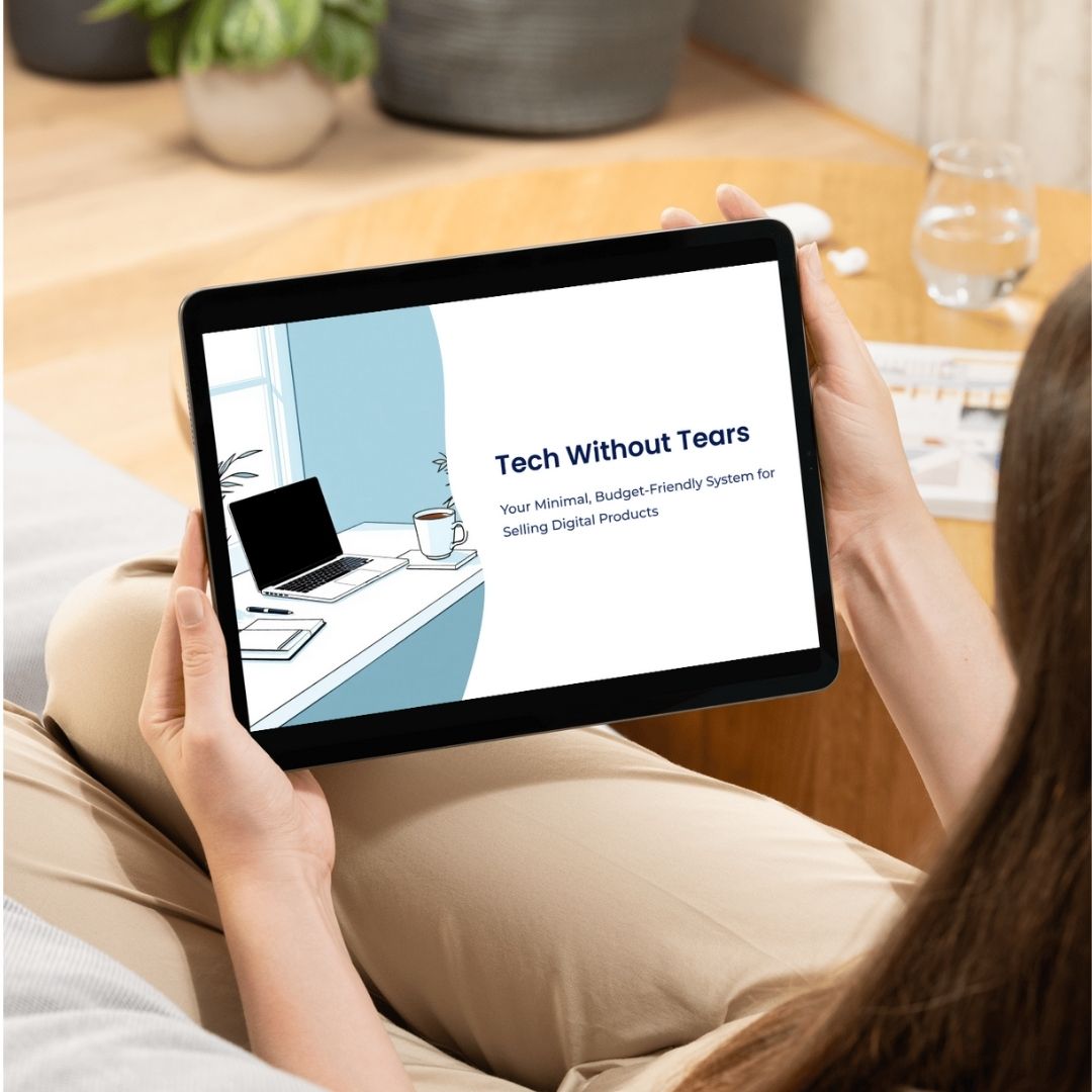 Person holding a tablet with 'Tech Without Tears' on the screen, sitting on a couch.
